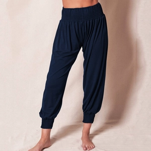 Detail of high waisted dark blue harem pants featuring elastic pleated waistband and cuffs