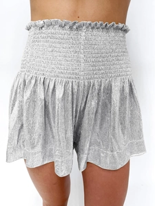 Detail of silver metallic high waist shorts with smocked elastic waistband and shimmer fabric