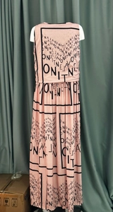 Detail van roze mouwloze maxi-jurk met zwarte letteropdruk en een klassieke ronde hals