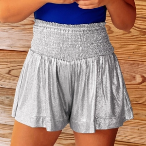 Detailed view of elastic high waist and shiny silver metallic texture on loose sports shorts
