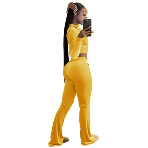 Detail of yellow velvet crop top and high-waisted flared trousers side view