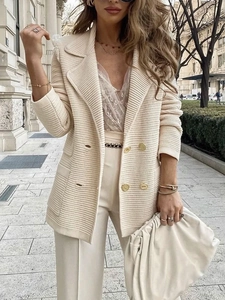 Detail der Textur des beige gestrickten Blazers mit Revers und goldenen zweireihigen Knöpfen