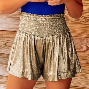 Detail of champagne gold metallic high-waisted shorts with elastic gathered waistband