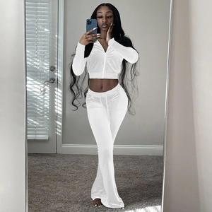 Close-up of white velvet two-piece set featuring slim-fit zip hoodie and flared trousers