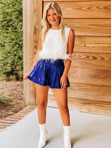 Detail of royal blue sequin shorts featuring an elastic drawstring waist and glossy finish