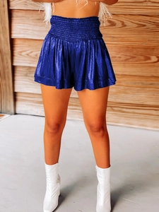 Detailed macro view of royal blue metallic fabric with pleated texture on high-waist shorts