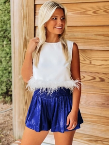 Detail of blue sequin shorts with elastic waist and white feather trim on sleeveless top