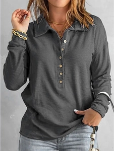 Détail du polo gris anthracite en maille gaufrée avec des boutons beiges élégants