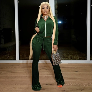 Detail view of dark green velvet two-piece tracksuit with zip-up jacket and flare pants