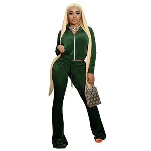 Detailed close-up of dark green velvet fabric on a slim zip jacket and flared pants set