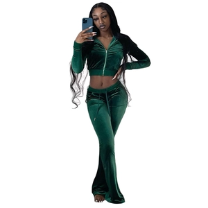 Detail of dark green velvet tracksuit featuring a cropped zip hoodie and flare pants