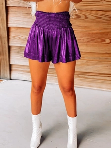 Detail of purple metallic smocked waist shorts with shiny pleated texture for party wear