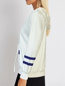 Detail of white ribbed knit hoodie showing sleeve stripes and adjustable drawstrings