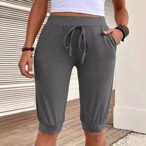 Women's dark gray capri yoga pants with drawstring waist and pockets on outdoor deck
