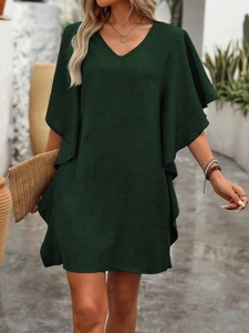Detail of the V-neckline and ruffled wide sleeves on a loose green summer dress