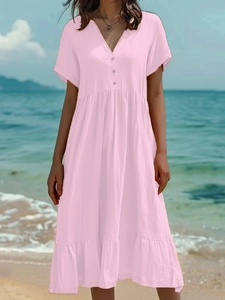 Détail d'une robe rose à manches courtes, col en V, boutons et volants de style vacances