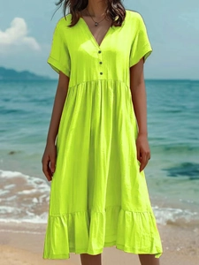 Détail de la robe jaune néon à col en V avec boutons noirs et tissu plissé texturé