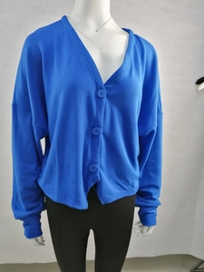 Détail d'un cardigan en maille bleu vif avec col en V et boutons assortis