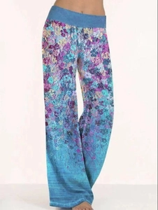 Dettaglio dei pantaloni da yoga a gamba larga a vita alta con motivo floreale blu e viola