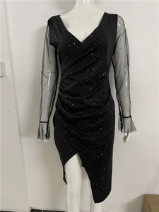 Close-up of black V-neck sequin dress showing sheer mesh sleeves and waist pleats