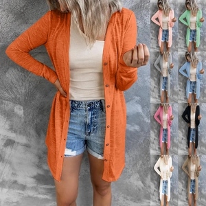 Detail view of a long-sleeved buttoned cardigan in various colors on a textured wall