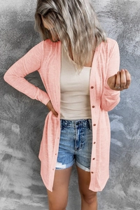 Detail of light pink knitted cardigan with wooden buttons and soft breathable fabric