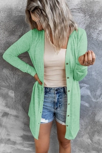 Close-up of light green knit cardigan with dark buttons and soft ribbed texture