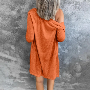 Back view of a long-sleeved orange knit cardigan featuring a textured drop-shoulder fit