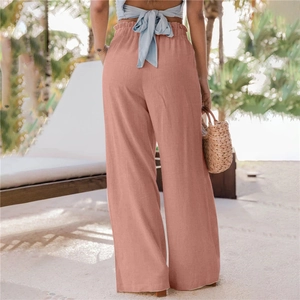 Dettaglio della vita alta a sacchetto con volant sui pantaloni larghi color rosa antico