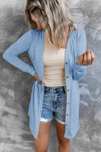Detail of light blue button-up long cardigan showing wood buttons and textured fabric