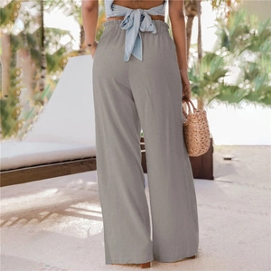 Dettaglio dei pantaloni larghi grigi a vita alta con elastico e trama di lino naturale