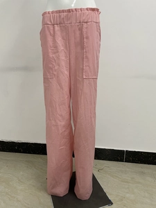 Dettaglio dei pantaloni rosa a gamba larga con vita elastica a balze e maxi tasche