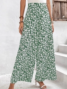 Détail d'un pantalon large à taille haute avec imprimé floral vert style vacances d'été