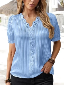 Light blue V-neck short sleeve shirt with lace trim and pleated texture in sunny outdoor setting
