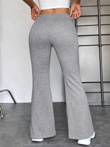 Rear view detail of high-waisted grey flared yoga pants with a slimming knit fit
