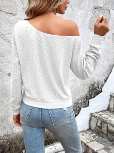 Detail of white long sleeve top featuring diamond mesh texture and off-shoulder design