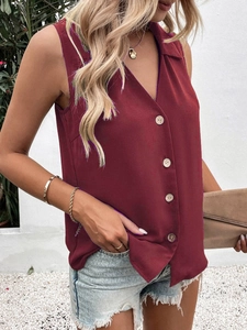 Close-up of wine red V-neck sleeveless chiffon blouse with brown buttons in sunlight