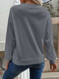 Detail eines grauen Sweatshirts aus Waffelstrick mit strukturierter Textur und lockerer Form