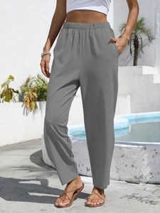 Close-up of high-waist elastic waistband and deep pockets on grey linen pants