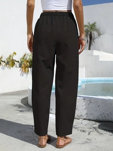 Detail view of black linen high waist elastic pants with a loose fit and textured fabric