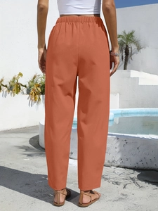 Rear view of bright orange linen-style high waist trousers with elastic waistband