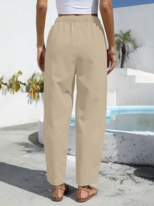 Detail of high-waisted khaki cotton linen trousers with elastic waistband and relaxed fit