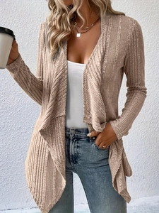Detail of light beige knit cardigan featuring ribbed texture and irregular draped hemline