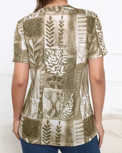 Detail view of the back of a women's t-shirt with olive green artistic botanical prints