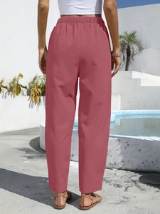 Detail showing elastic high waistband and linen fabric texture of pink leisure trousers
