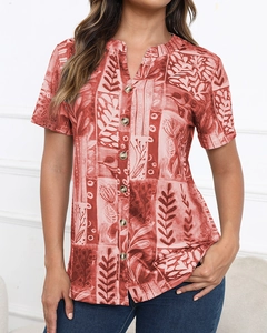 Detail of red-brown short sleeve shirt with white abstract print and button-up v-neck