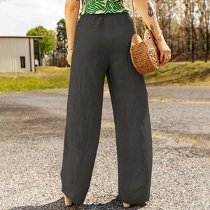 Back view of high-waist black linen wide-leg pants showing a loose fit and elegant drape