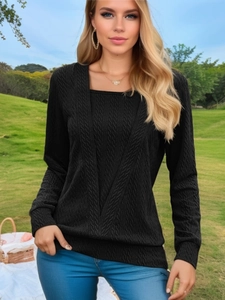 Detail of black long sleeve knit top featuring a square neck and textured cable patterns