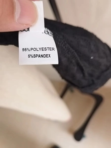 Detail shot of care label showing 95% polyester and 5% spandex fabric composition