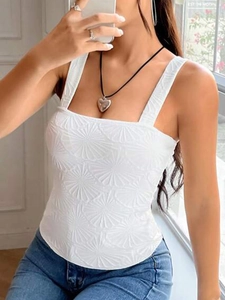 Detailed close-up of white jacquard camisole fabric with embossed floral patterns